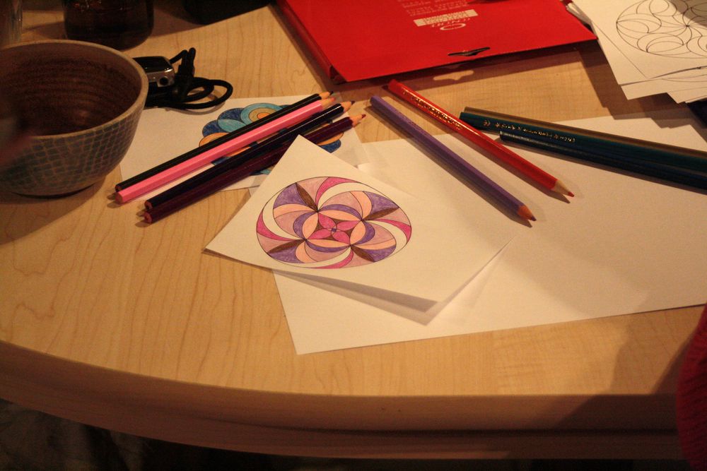 Vybarvená mandala na stole s pastelkami