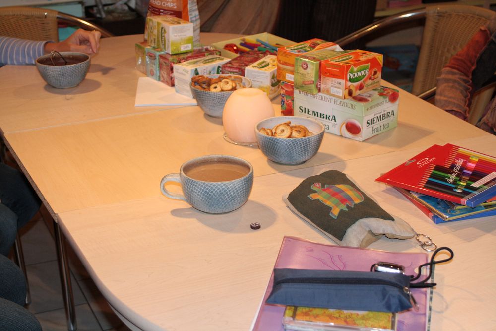Prostřený stůl s čajem, kávou a pastelkami